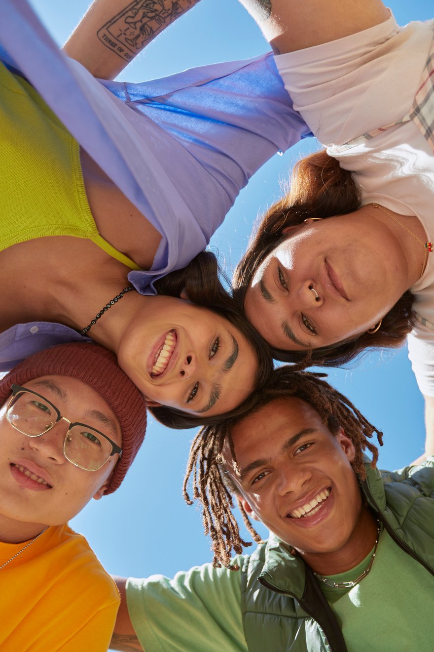 a group of people in a close circle looking down at the camera