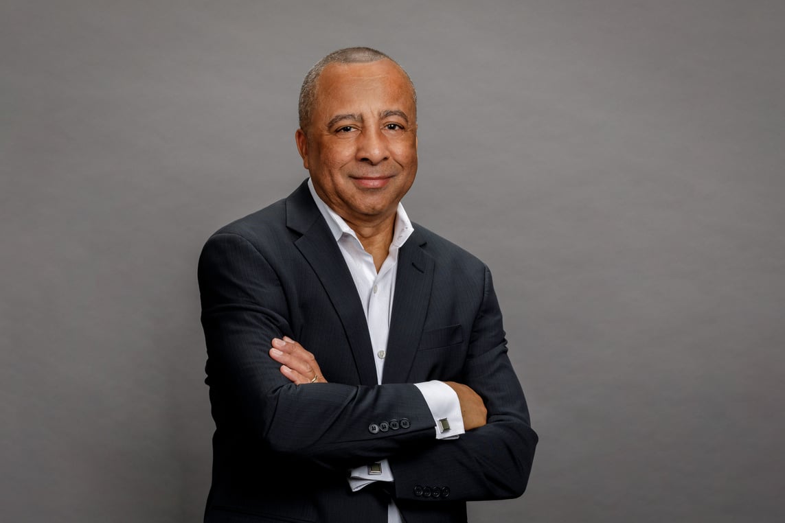 company owner in a suit and tie standing with his arms crossed