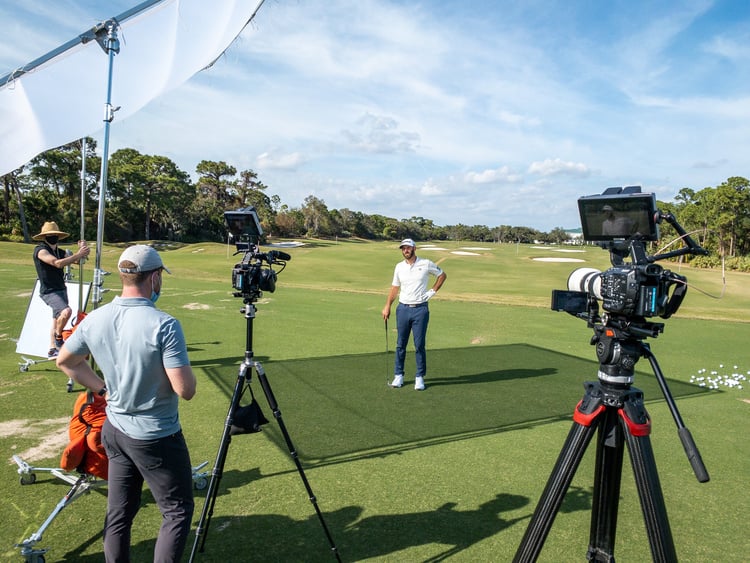 a group of people on a golf course with cameras